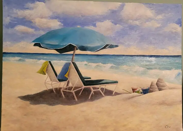Beach chairs under umbrella on sandy shore